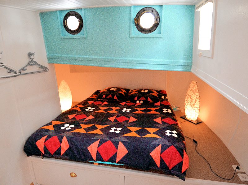 A 3rd double bedroom in its corner alcove beneath the portholes.
