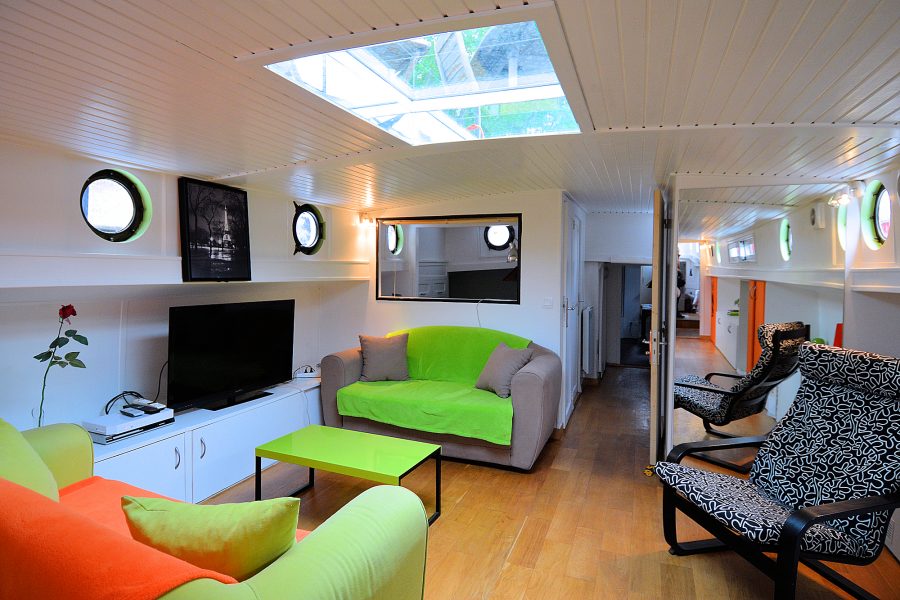 Spacious Living Room with flat-screen TV, portholes, & skylight.