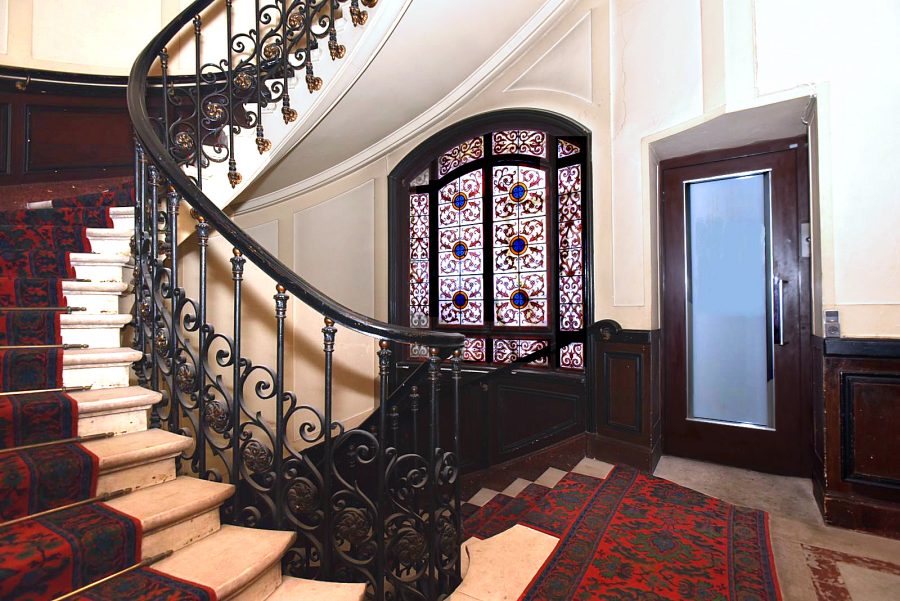 A small elevator is strategically placed near the apartment entry doors.