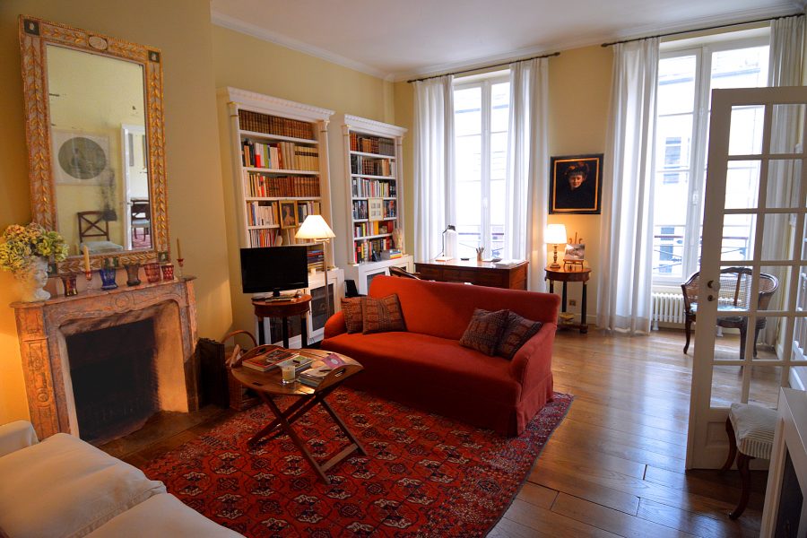 Living room with fireplace and TV plus study with writing desk and library.