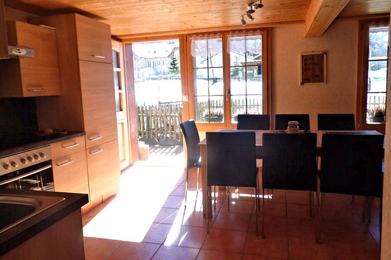 Chalet Bluemlisalp - open-plan dining and kitchen with patio and BBQ access