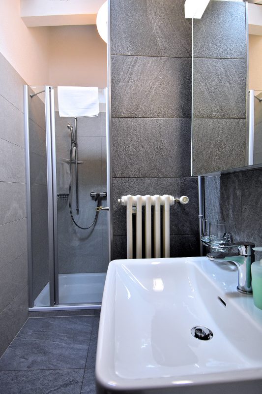 Home At First 1-bedroom apartment — bathroom with shower.