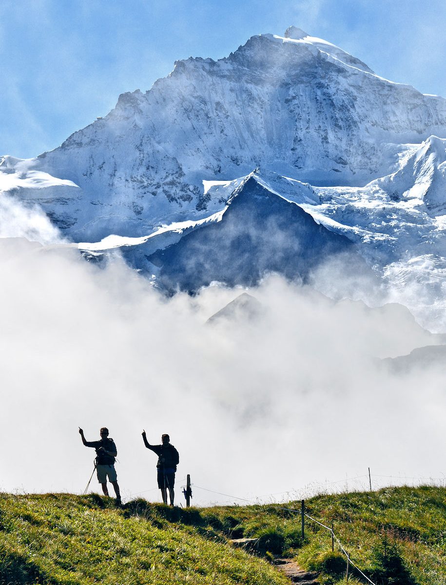 Hikers silhouetted on ridge trail