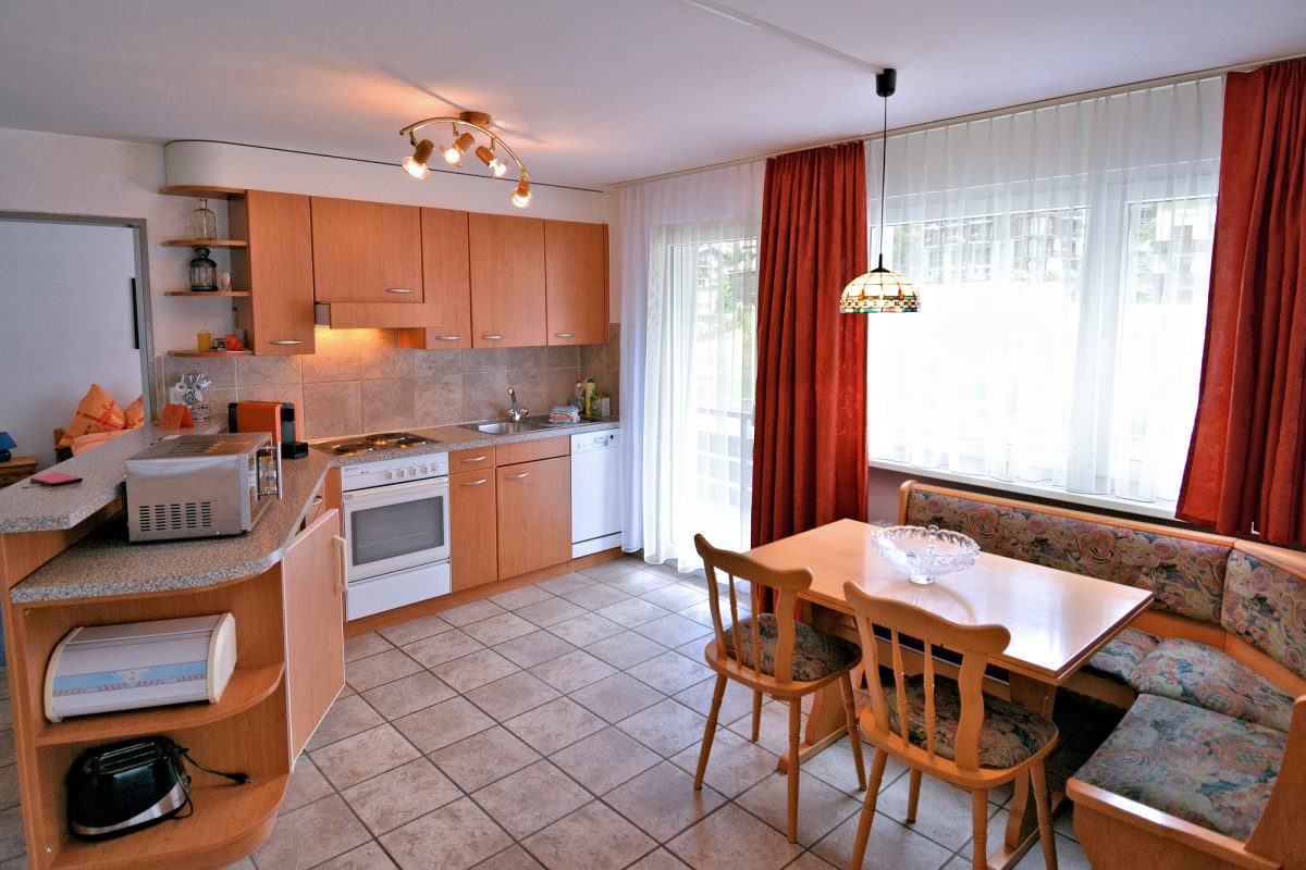 Riverview Apartment — Kitchen with eat-in dining and balcony access.