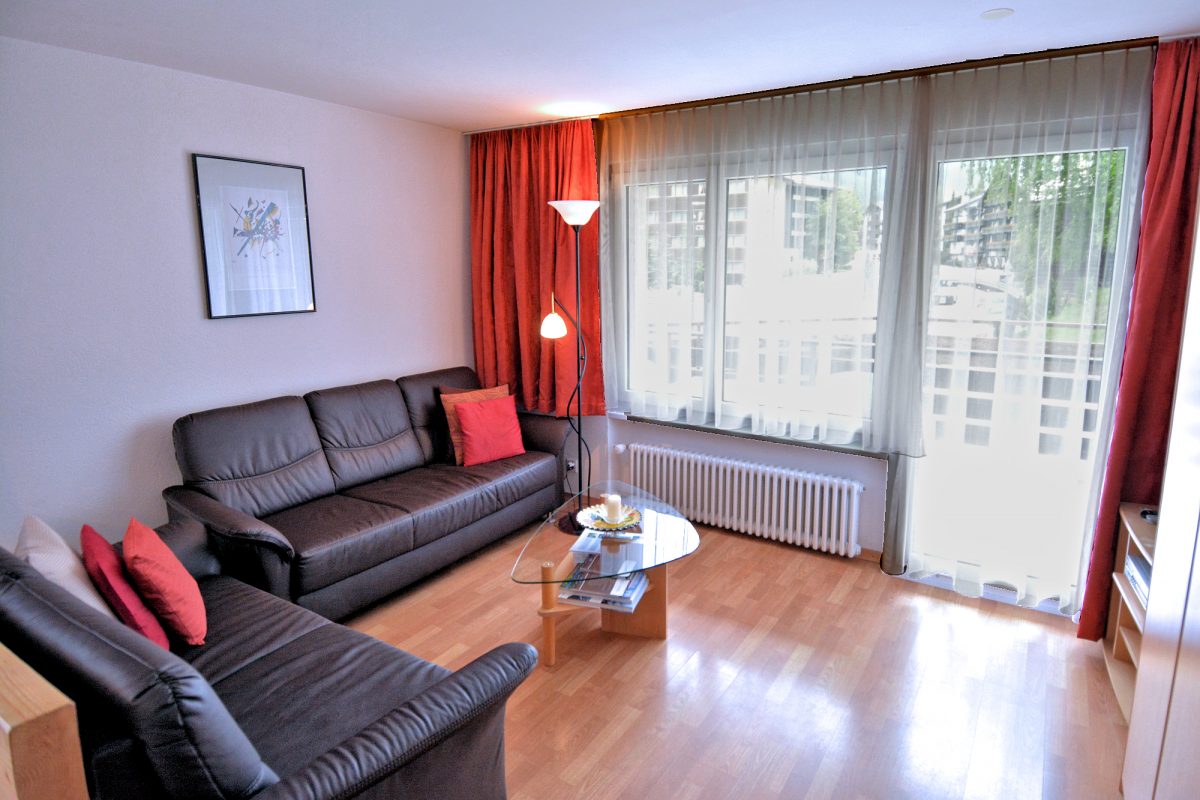 Riverview Apartment — Living room with balcony access.
