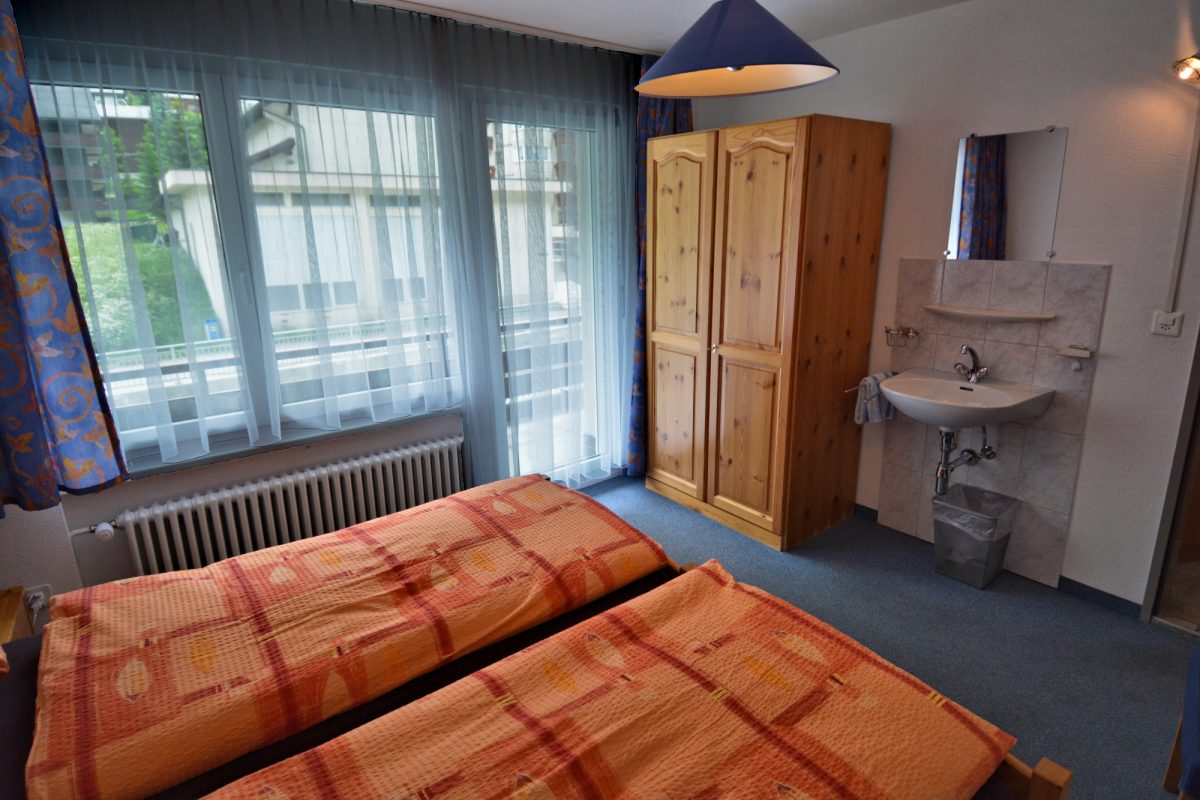 Riverview Apt — Twin Bedroom #1 w. sink and balcony access.