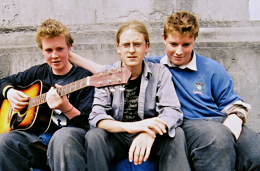 Three Irish lads with a guitar.