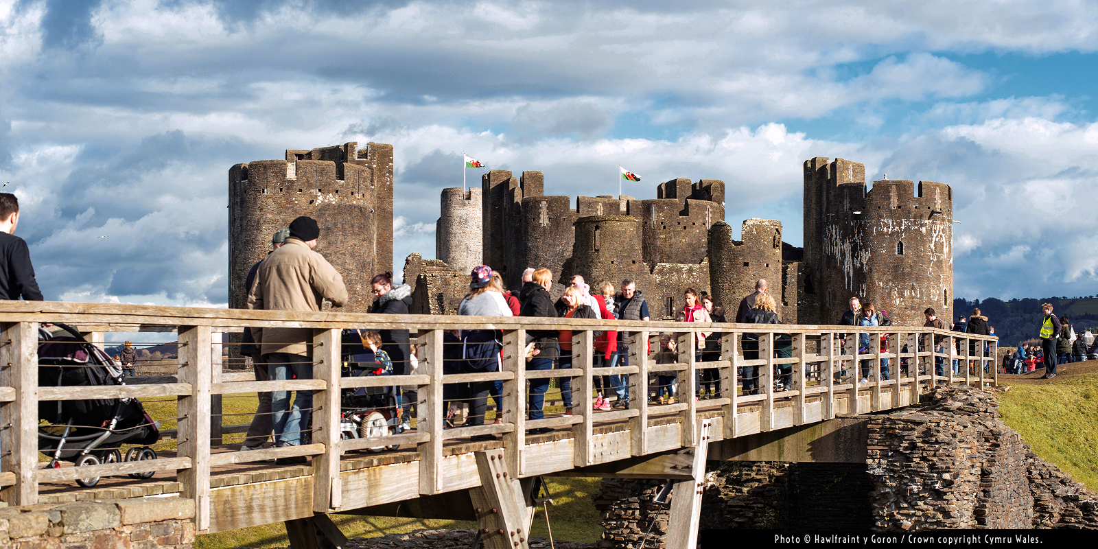 Caerphilly Castle: visitors crossing the drawbridge. Photo © Hawlfraint y Goron / Crown copyright Cymru Wales. Caerphilly Castle: visitors crossing the drawbridge. Photo © Hawlfraint y Goron / Crown copyright Cymru Wales.