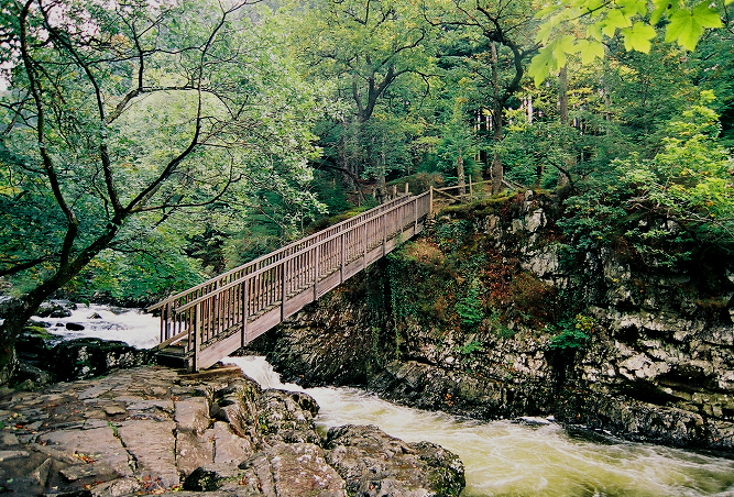 Betws-y-Coed Snowdonia — Footbridge at Swallow Falls. You can walk here and on many other trails from Home At First's Wales vacation cottages in Betws-y-Coed. Photo © Home At First. Betws-y-Coed Snowdonia — Footbridge at Swallow Falls. Photo © Home At First.