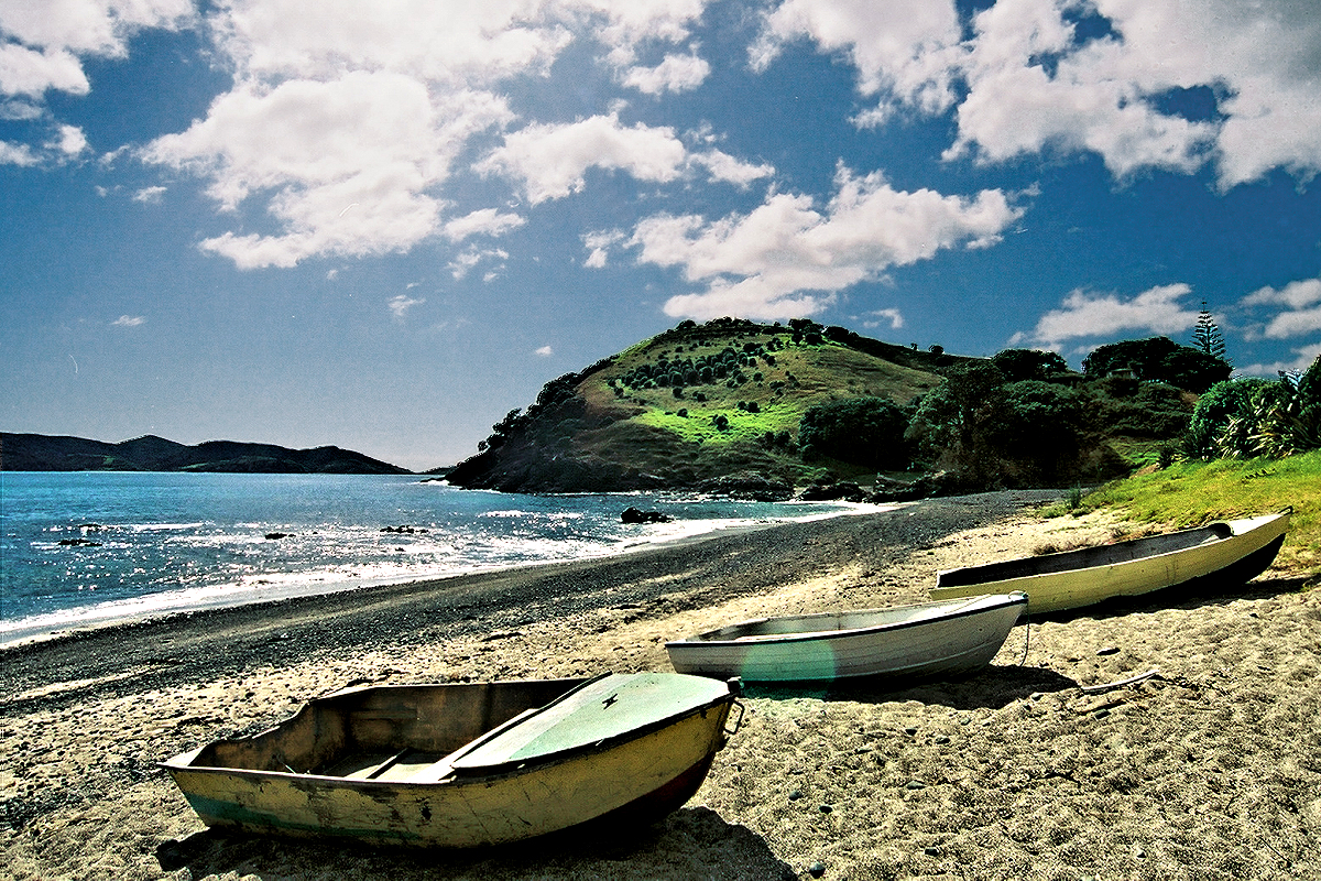 Northland: volcanic headlands, black sand beaches, turquoise waters, and deep blue skies. Photo © Home At First.