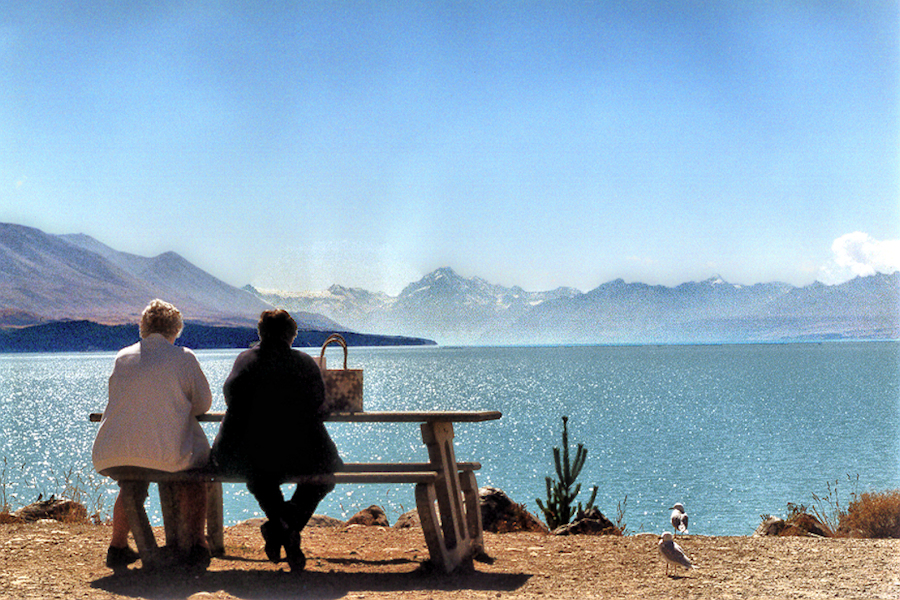 South Island — Mackenzie Country: Lake Pukaki picnickers with Southern Alps. Photo © Home At First.