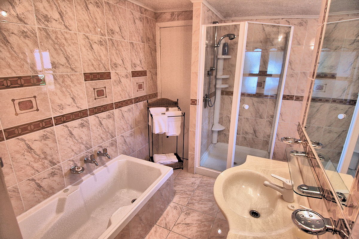 Rainbow Lodge: bathroom 2 with tub and shower. Photo © Home At First.